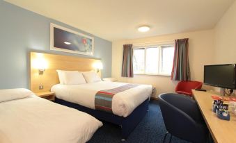 a hotel room with three beds , one on the left , one in the middle , and one on the right at Travelodge Glenrothes