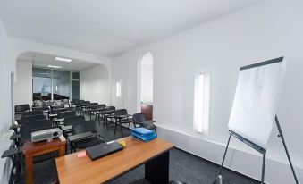 a conference room with a wooden table , chairs , and a whiteboard , set up for a meeting at Hotel Opal