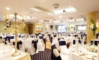 a large banquet hall with tables covered in white tablecloths and chairs arranged for a formal event at Tara Hotel