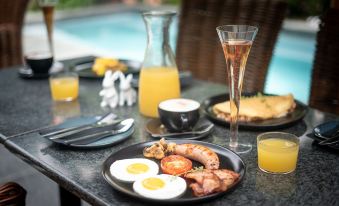 a table is set with plates of food , including eggs and toast , accompanied by glasses of orange juice at Ruby Rose
