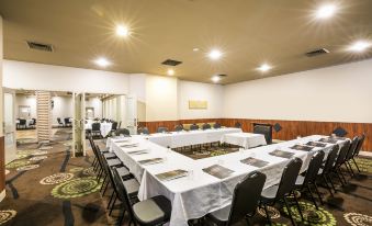 a conference room set up for a meeting , with tables and chairs arranged in a semicircle formation at Nightcap at Waltzing Matilda Hotel