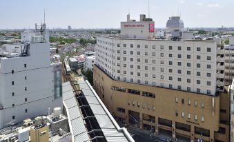 a cityscape with a mix of modern and older buildings , including a large white building with a red roof at Kichijoji Tokyu Rei Hotel
