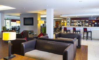 a spacious living room with several couches and chairs , creating a comfortable and inviting atmosphere at Holiday Inn Express Northampton - South