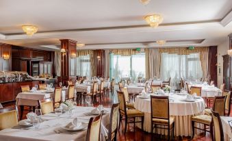 a large dining room with tables and chairs arranged for a group of people to enjoy a meal together at Hotel President Solin