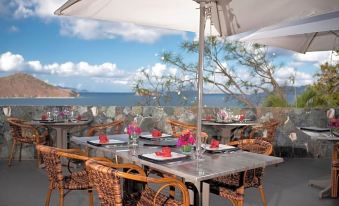 an outdoor dining area with a table set for dinner , surrounded by chairs and umbrellas at Point Pleasant Resort