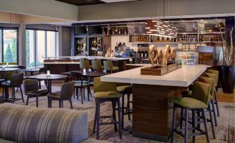 a modern restaurant with a bar and dining area , featuring comfortable seating and a bar counter at Courtyard Detroit Dearborn