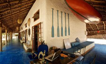 a room with a blue couch and blue chair , a wooden bench , and a surfboard hanging on the wall at Dolphin Beach Resort