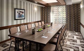 a long dining table with chairs , wine glasses , and a framed picture on the wall at Courtyard Seattle North/Lynnwood Everett