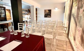 a room with white chairs and a red table set up for an event , possibly a wedding reception at Hotel Joli