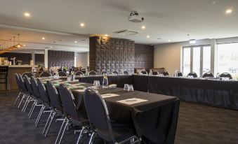 a large conference room with multiple rows of chairs arranged in a semicircle , ready for a meeting at Marsden Lake Resort Central Otago