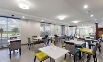 a large , modern dining room with several tables and chairs arranged for a group of people at Comfort Inn & Suites Victoria North