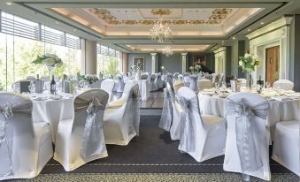 a large , elegant banquet hall with multiple tables set for a formal event , including white tablecloths , chairs , and decorations at Stamford Plaza Adelaide