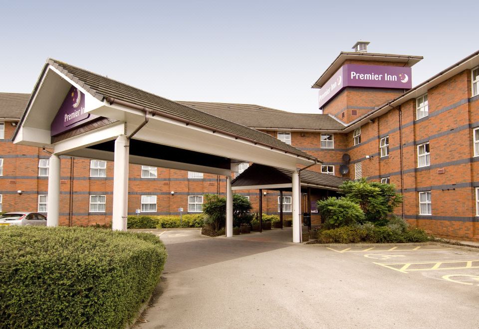 "a brick building with a covered entrance and a sign that reads "" premier inn "" above it" at Premier Inn Derby East