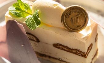a slice of cake with a scoop of ice cream on top and a medal next to it at Hotel Europe