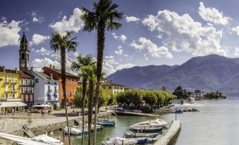 a picturesque town with boats docked at a harbor , surrounded by palm trees and mountains in the background at Aries