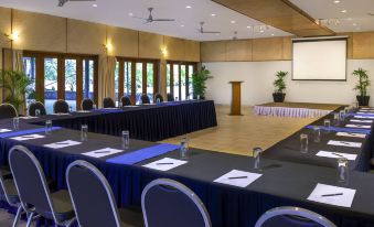 a large conference room with multiple rows of chairs arranged in a semicircle around a long table at Novotel Suva Lami Bay