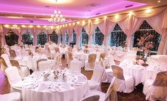 a large banquet hall with multiple tables covered in white tablecloths and chairs arranged for a formal event at The Inn at Dromoland