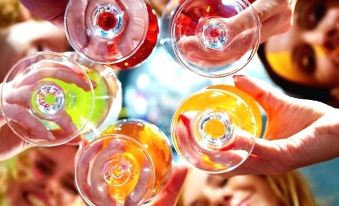 a group of people holding wine glasses filled with various colored liquids , enjoying each other 's company at The Prince Consort
