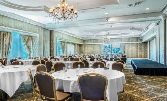 a large conference room with multiple round tables and chairs , set up for a formal event at Stamford Plaza Brisbane