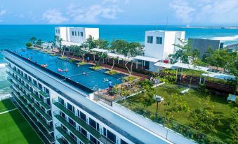 a rooftop swimming pool surrounded by buildings , with people enjoying their time in the pool at Marino Beach Colombo
