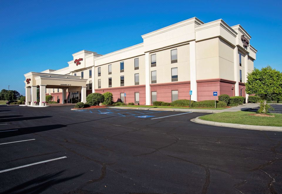a large hotel with a red roof and white walls is shown in the daytime at Hampton Inn Moultrie
