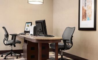 a desk with two computer monitors , a keyboard , and a mouse is set up in an office space at Homewood Suites by Hilton Columbus - Hilliard