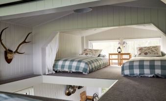 a cozy bedroom with two beds , one on top of the other , and a window with a view at Extraordinary Huts