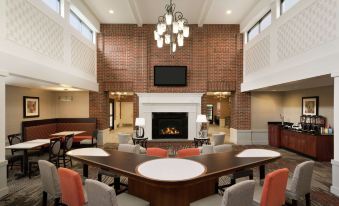 a spacious dining room with a large table surrounded by chairs and a fireplace in the background at Homewood Suites by Hilton Newtown - Langhorne