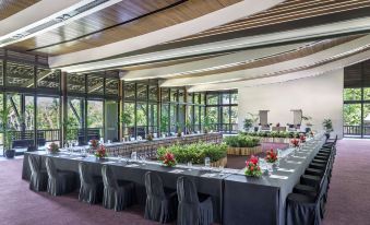a long table is set up in a large room with chairs and plants on the sides at Shangri-La Yanuca Island, Fiji