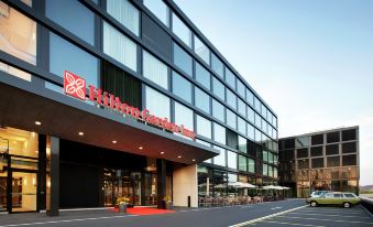 "a modern building with a red sign that reads "" hilton garden inn "" on the front" at Hilton Garden Inn Zurich Limmattal