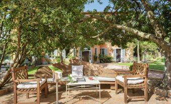 a large wooden house surrounded by trees , with several chairs and tables placed around the property at Hotel Vannucci