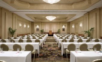 A spacious room is arranged with tables and chairs for hosting events or formal functions at The Royal Hawaiian, A Luxury Collection Resort, Waikiki