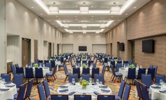 a large banquet hall with numerous round tables and chairs set up for a formal event at Embassy Suites by Hilton South Jordan Salt Lake City