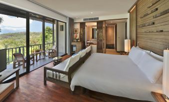 a spacious bedroom with a king - sized bed , hardwood floors , and a large window overlooking the ocean at Pimalai Resort & Spa