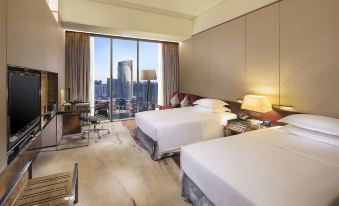 The bedroom features double beds, large windows, and a city view at Hilton Guangzhou Tianhe