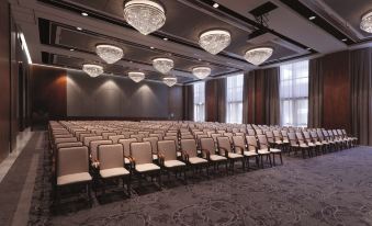 a large conference room with rows of chairs arranged in a semicircle , and a chandelier hanging from the ceiling at Conrad Algarve