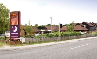 a large billboard is next to a street with a house and trees in the background at Sandhurst