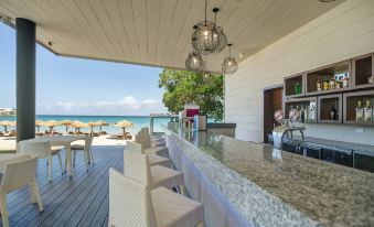 a beach house with a large outdoor kitchen area , where a dining table and chairs are set up for a meal at Royalton Negril, An Autograph Collection All-Inclusive Resort