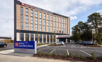 a hilton garden inn hotel with its large , modern facade and surrounding parking lot , under a blue sky with clouds at Hilton Garden Inn Doncaster Racecourse