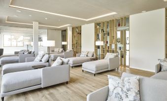 a large , modern living room with multiple couches and chairs arranged in a seating area at Steigenberger Hotel and Spa, Krems