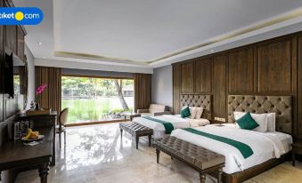 a spacious bedroom with two beds , a couch , and a large window overlooking a body of water at The Westlake Hotel & Resort Yogyakarta