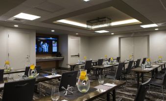 a conference room with several tables and chairs arranged for a meeting , with a tv mounted on the wall at Renaissance Allentown Hotel