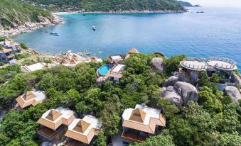 aerial view of a resort on a hillside overlooking the ocean , with multiple buildings and a pool at Sai Daeng Resort