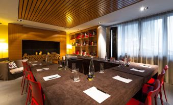 a long dining table set up for a meeting , with several chairs arranged around it at Hotel le Morgane