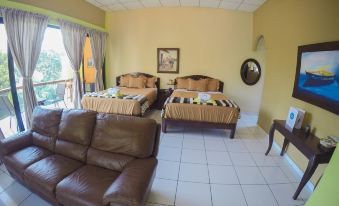 a living room with two beds , one on each side of the room , and a couch in the middle at Hotel Estero y Mar