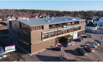 "a large building with a sign that says "" superstore "" is surrounded by a parking lot" at L'Hotel