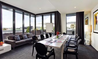 a conference room with a long table , chairs , and large windows , ready for an event at The Cullen Melbourne - Art Series