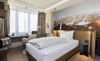 a large bed with white linens is situated in a hotel room next to a window at Hotel Innsbruck
