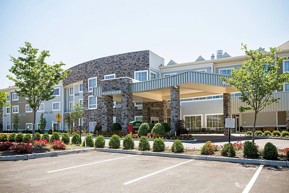 a large building with a covered entrance and a parking lot in front of it at Courtyard Philadelphia Springfield