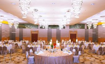 a large banquet hall with multiple tables and chairs set up for a formal event , possibly a wedding reception at Palm Seremban Hotel